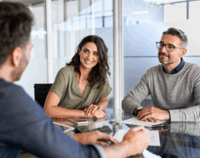 A couple meeting with an advisor, representing the idea of preparing a ‘to-do’ list for making your will.
