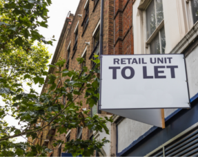Photo of a sign on the side of a building with the words 'Retail Unit to Let'.