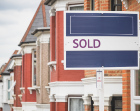Sold sign displayed outside a terraced house in London.