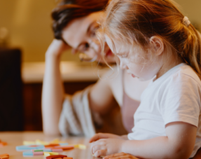 Photo of a child playing board games with her mother.