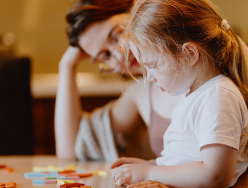 Photo of a child playing board games with her mother.